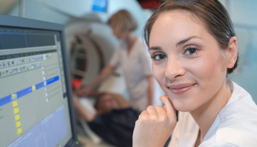 erson undergoing an MRI scan, monitored by a medical professional.